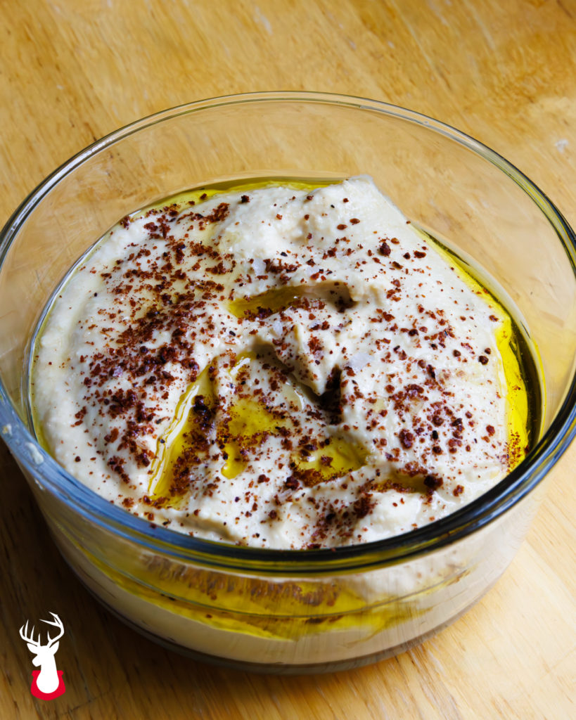 Homemade hummus topped with olive oil and sumac